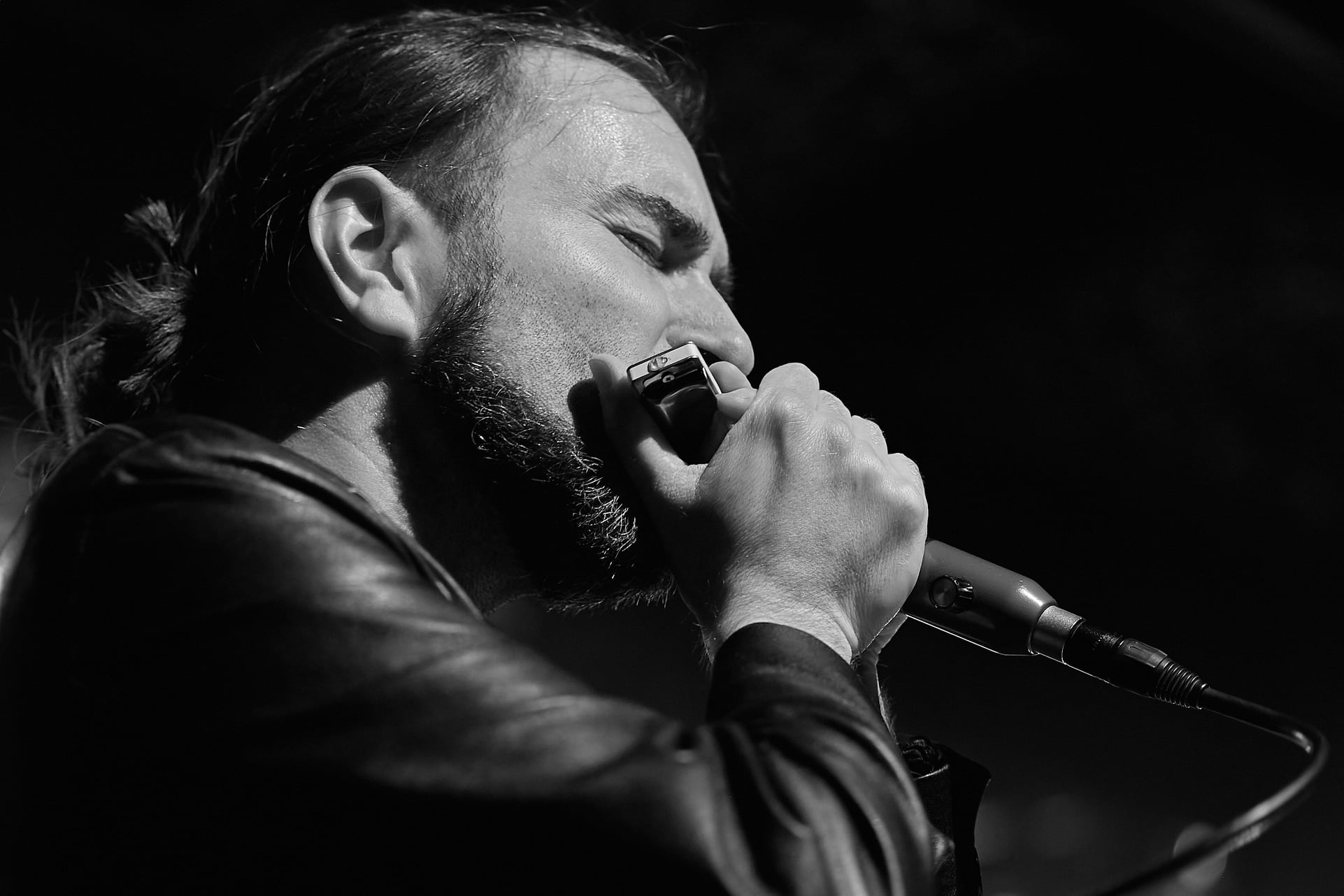 Manlio Milazzi singing into a microphone, black and white portrait